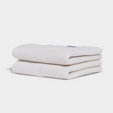 white hand towel sitting in stack on white background