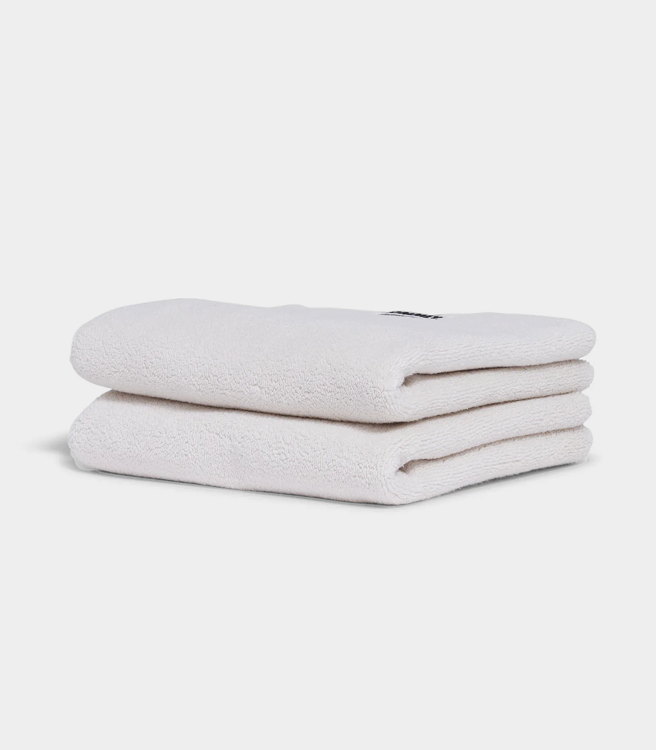 white hand towel sitting in stack on white background