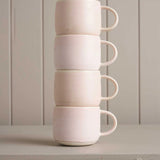 pink mugs sitting on a wooden shelf