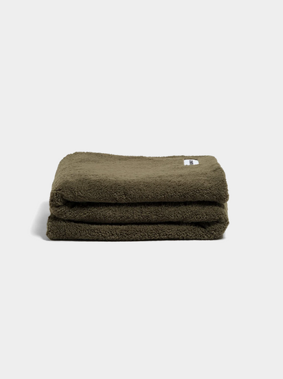 green fluffy throw blanket on white background