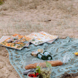 paint by numbers kit sitting on a picnic blanket on a beach