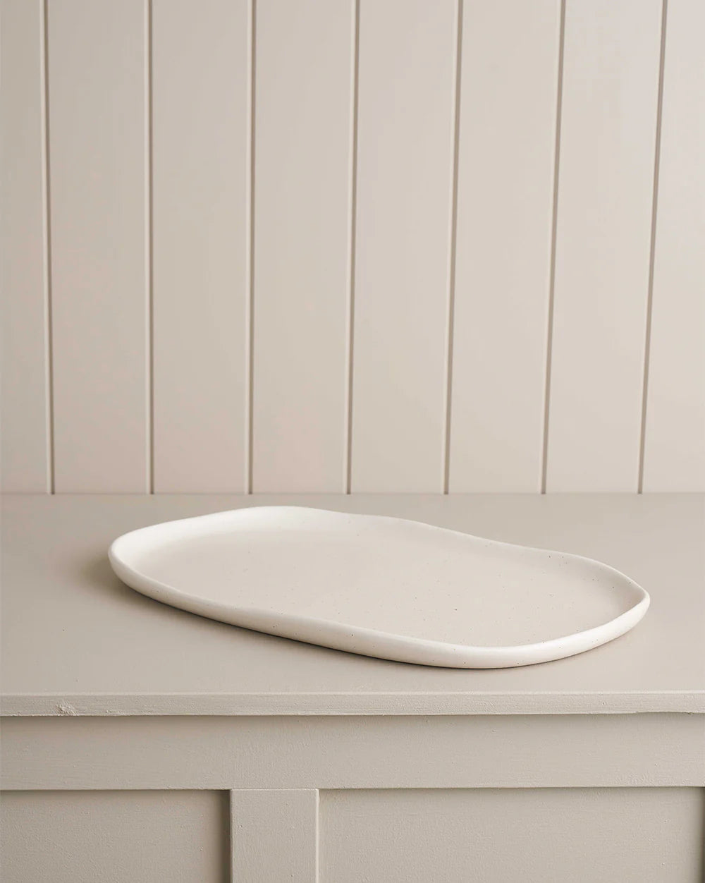 white large oblong platter on wooden shelf