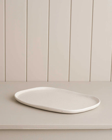 white small oblong platter on wooden shelf