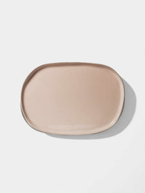 Oval blush ceramic platter with an organic handcrafted design for serving appetizers.