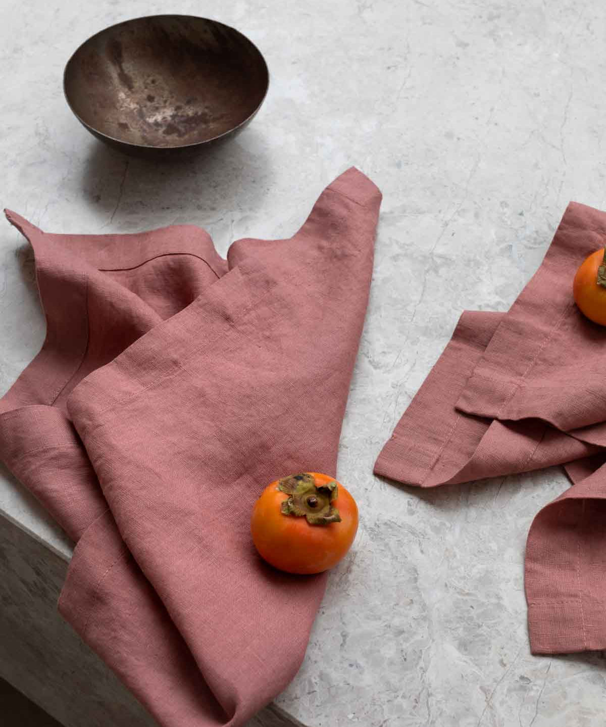 rose pink napkins sitting on a marble table
