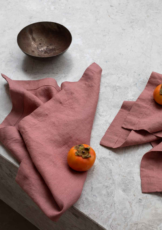 rose pink napkins sitting on a marble table