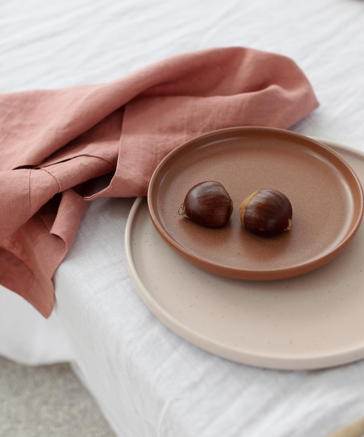 rose pink napkin wrapped around a plate with food on it 
