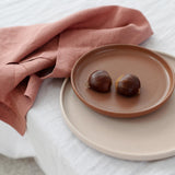 rose pink napkin wrapped around a plate with food on it 