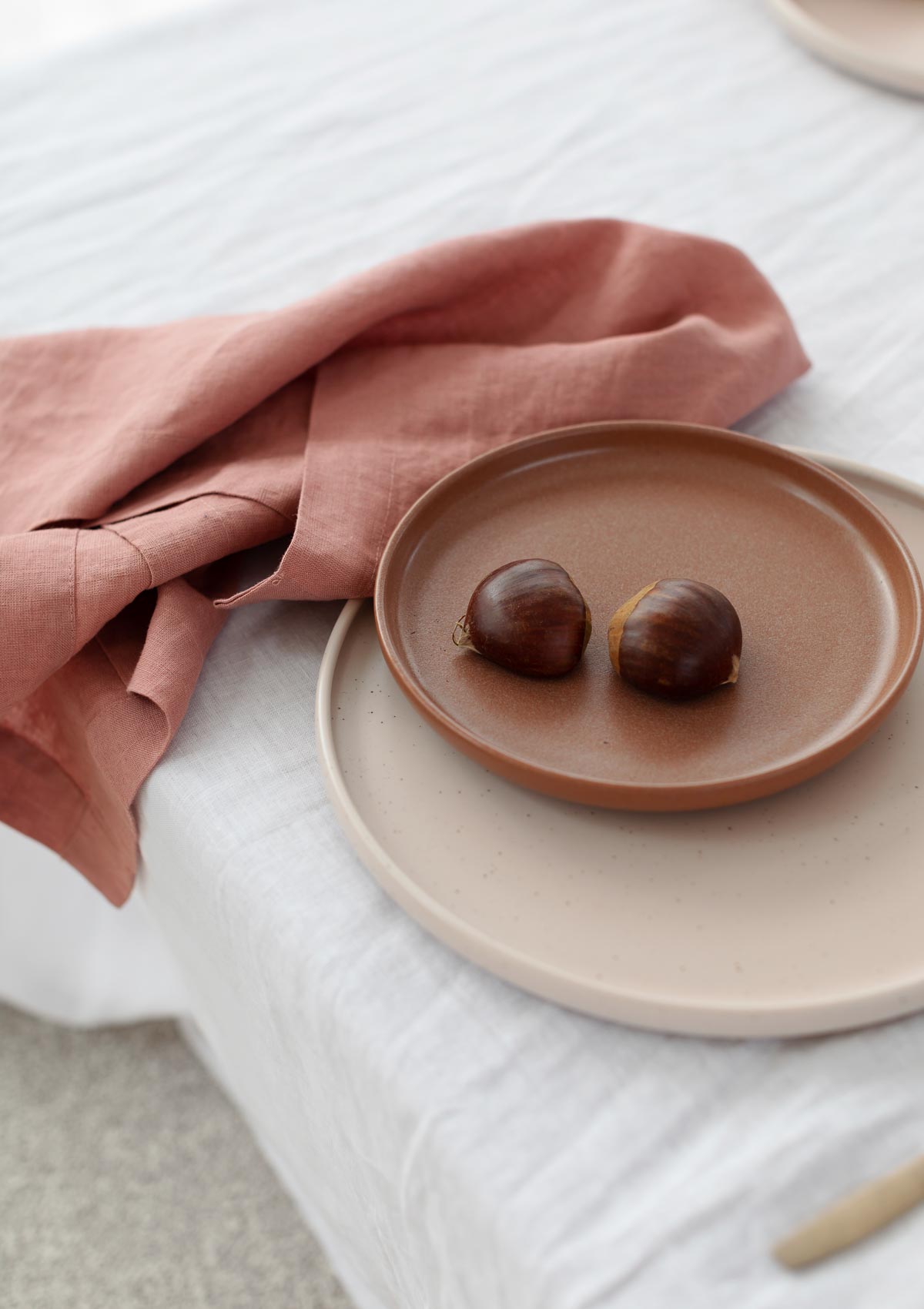 rose pink napkin wrapped around a plate with food on it 