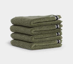 dark green face washer towels in stack on white background