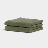 dark green hand towel sitting on white background