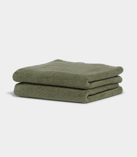 dark green hand towel sitting on white background