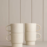 white mugs sitting on a wooden shelf 
