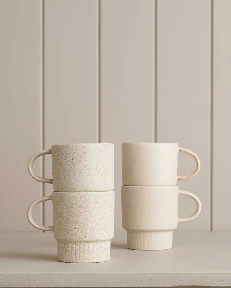 white mugs sitting on a wooden shelf 