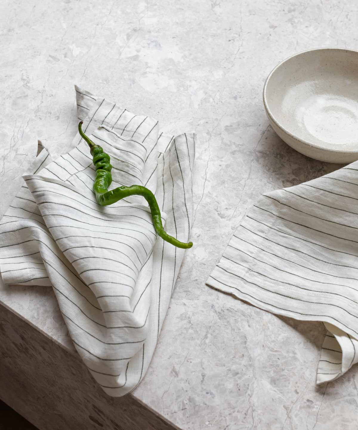 striped linen napkin sitting on a marble table 