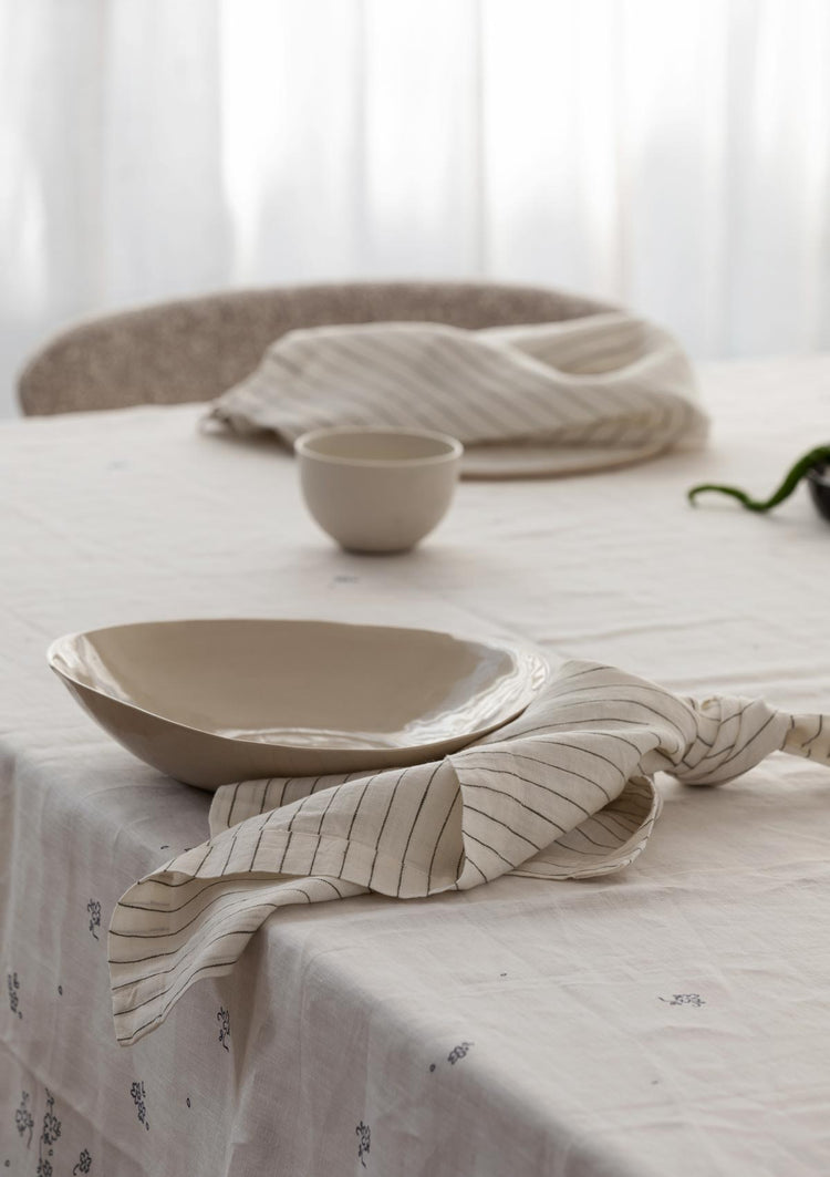 napkins and bowls sitting on a table with a tablecloth on it