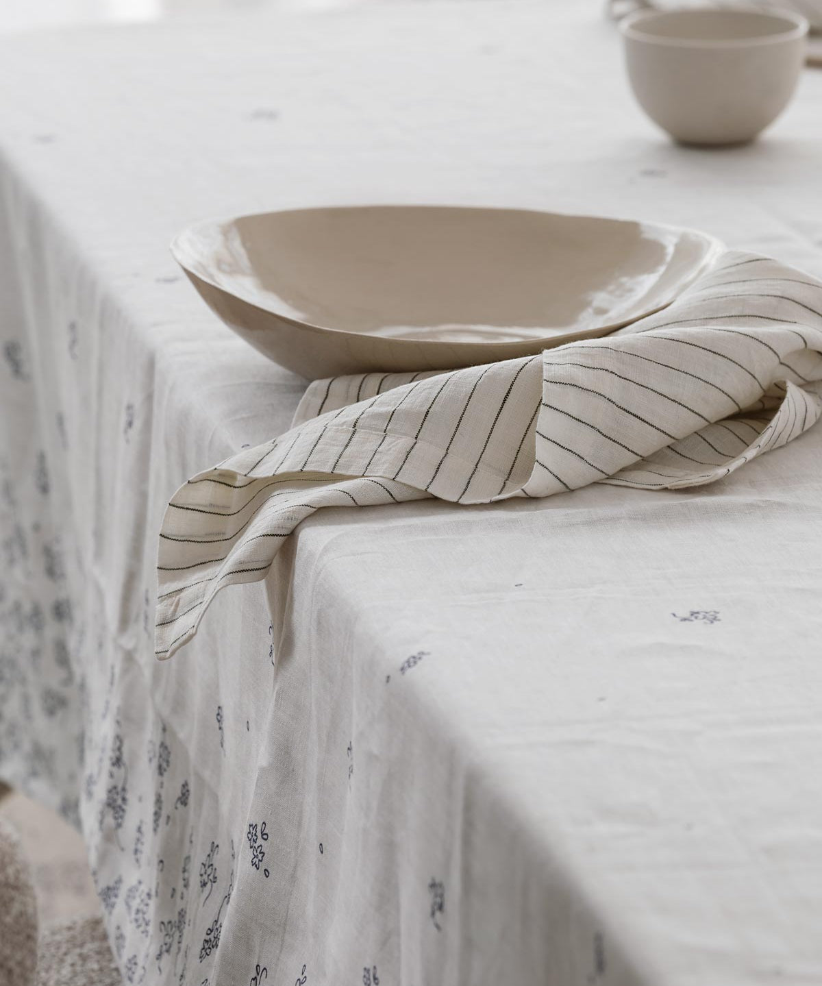 striped linen napkin sitting on a table with a tablecloth on it 