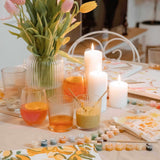 tablescape of paint by numbers kits, candles and food