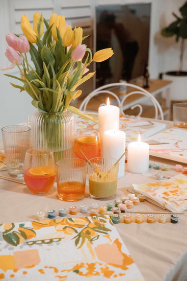 tablescape of paint by numbers kits, candles and food