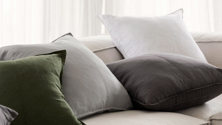 different coloured linen cushions scattered on a couch