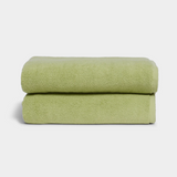 light green towel sitting in stack on white background