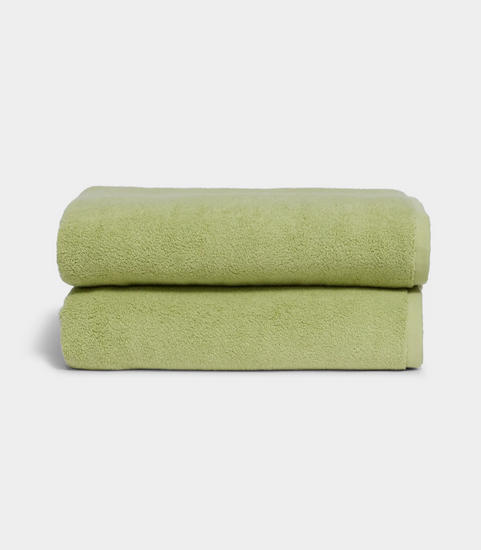 light green towel sitting in stack on white background