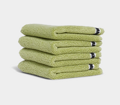 green face washer towels in stack on white background