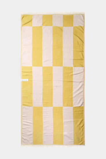 yellow and white beach towel laid out flat